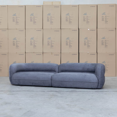 The Harper Curved Fabric Four Seat Sofa - Charcoal available to purchase from Warehouse Furniture Clearance at our next sale event.