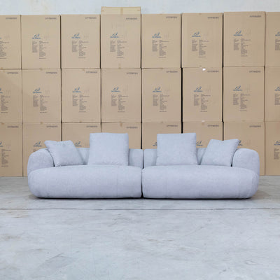 The Maven Curved Fabric Four Seat Sofa - Pewter available to purchase from Warehouse Furniture Clearance at our next sale event.