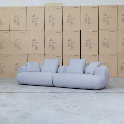 The Maven Curved Fabric Four Seat Sofa - Pewter available to purchase from Warehouse Furniture Clearance at our next sale event.