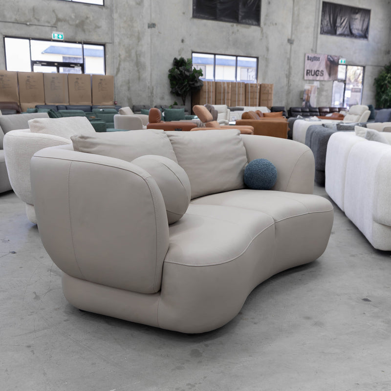 The COR-13033 2 seat leather curved sofa - Oatmeal - Floor Stock available to purchase from Warehouse Furniture Clearance at our next sale event.