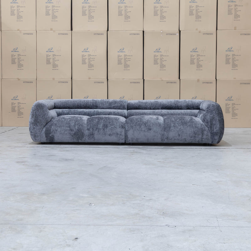 The Fara Curved Fabric Four Seat Sofa - Steel available to purchase from Warehouse Furniture Clearance at our next sale event.