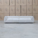The Fara Curved Fabric Four Seat Sofa - Cloud available to purchase from Warehouse Furniture Clearance at our next sale event.