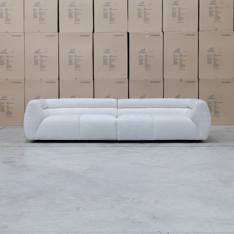 The Fara Curved Fabric Four Seat Sofa - Cloud available to purchase from Warehouse Furniture Clearance at our next sale event.