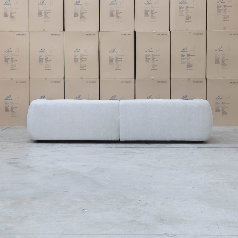 The Fara Curved Fabric Four Seat Sofa - Cloud available to purchase from Warehouse Furniture Clearance at our next sale event.