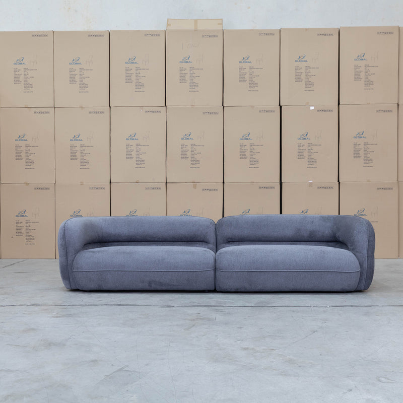 The Harper Curved Fabric Four Seat Sofa - Charcoal available to purchase from Warehouse Furniture Clearance at our next sale event.