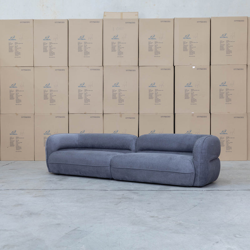 The Harper Curved Fabric Four Seat Sofa - Charcoal available to purchase from Warehouse Furniture Clearance at our next sale event.
