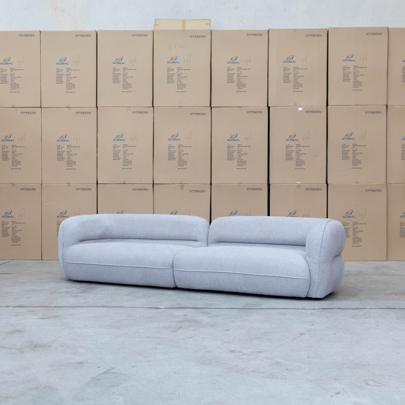 The Harper Curved Fabric Four Seat Sofa - Pewter available to purchase from Warehouse Furniture Clearance at our next sale event.