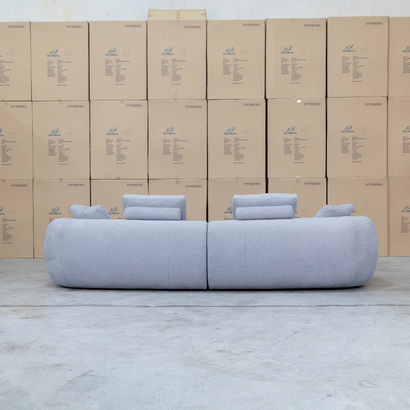 The Maven Curved Fabric Four Seat Sofa - Pewter available to purchase from Warehouse Furniture Clearance at our next sale event.