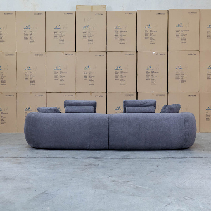 The Maven Curved Fabric Four Seat Sofa - Charcoal available to purchase from Warehouse Furniture Clearance at our next sale event.