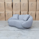 The Noosa Curved Fabric Two Seat Sofa - Light Grey available to purchase from Warehouse Furniture Clearance at our next sale event.
