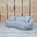 The Noosa Curved Fabric Three Seat Sofa - Light Grey available to purchase from Warehouse Furniture Clearance at our next sale event.
