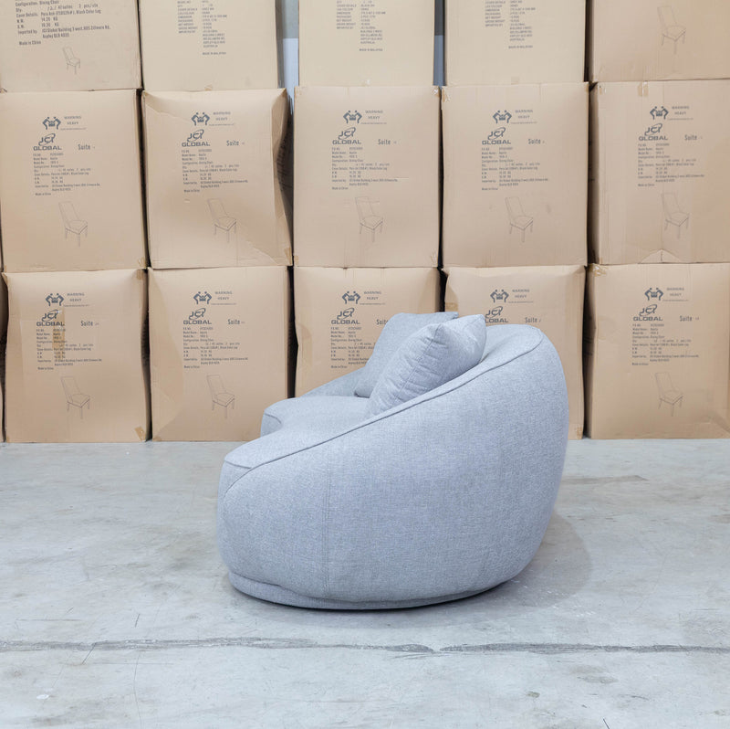 The Noosa Curved Fabric Three Seat Sofa - Light Grey available to purchase from Warehouse Furniture Clearance at our next sale event.