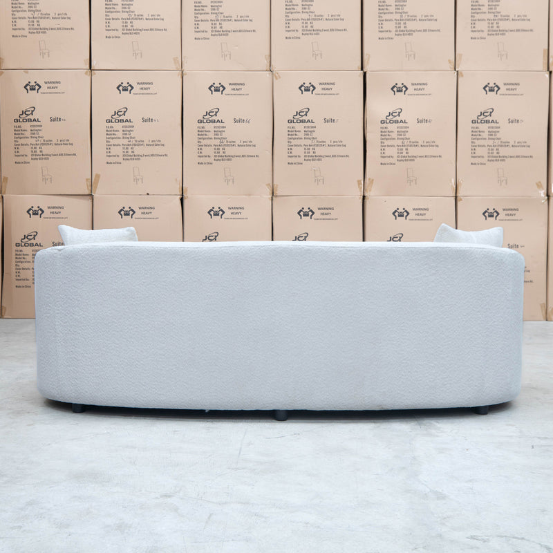 The Santorini Curved Three Seat Sofa - Boucle Ivory available to purchase from Warehouse Furniture Clearance at our next sale event.
