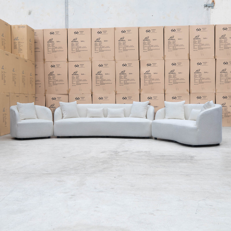 The Santorini Curved Three Seat Sofa - Boucle Ivory available to purchase from Warehouse Furniture Clearance at our next sale event.