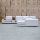 The Zenith Modular Reversible Corner Chaise Lounge With Bookshelf - Oat White available to purchase from Warehouse Furniture Clearance at our next sale event.